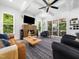 Cozy living room with modern fireplace, comfy seating, hardwood floors, and access to outdoor patio at 104 Blue Finch Ct, Youngsville, NC 27596