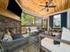 Relaxing screened-in porch featuring a stone fireplace, wood ceiling, and comfortable seating at 104 Blue Finch Ct, Youngsville, NC 27596