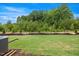 A home's backyard features lush green grass, partial fence and view of mature trees at 1048 Winding Spring Dr, Mebane, NC 27302