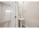 Half bath featuring a pedestal sink, oval mirror, and brushed nickel fixtures at 1048 Winding Spring Dr, Mebane, NC 27302