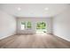 Bright and airy living room featuring hardwood floors, neutral walls, and a sliding glass door to the backyard at 1048 Winding Spring Dr, Mebane, NC 27302