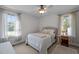 Cozy bedroom with neutral decor, including a comfortable bed, two windows, and neutral walls and carpet at 108 Ruff Davis Rd, Roxboro, NC 27574