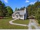 Beautiful single-story house with a metal roof, gray siding, and covered parking surrounded by lush greenery under a blue sky at 108 Ruff Davis Rd, Roxboro, NC 27574