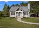 Charming one-story home with a metal roof, gray siding, and a welcoming walkway, plus covered parking on a lush, green lot at 108 Ruff Davis Rd, Roxboro, NC 27574