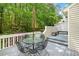 Outdoor deck with a glass table, iron chairs, and a wooded view at 108 Woodglen Dr, Cary, NC 27518