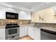 Well-lit kitchen with granite counters, stainless steel appliances, white cabinets and a stainless dishwasher at 108 Woodglen Dr, Cary, NC 27518