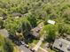 Aerial view showcases the property surrounded by mature trees in a residential neighborhood at 109 N Hassel St, Hillsborough, NC 27278