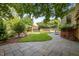 Beautiful backyard with a stone patio, lush lawn, and a charming pergola amidst mature trees at 109 N Hassel St, Hillsborough, NC 27278
