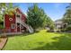 Expansive backyard featuring lush lawn, mature trees, and charming red barn-style house at 109 N Hassel St, Hillsborough, NC 27278