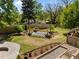 Lush backyard featuring a wooden pergola, stone pathways, and mature trees, creating a serene outdoor space at 109 N Hassel St, Hillsborough, NC 27278