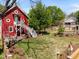 Charming backyard featuring a red building, lush lawn, mature trees, and lovely landscaping details at 109 N Hassel St, Hillsborough, NC 27278