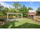 Expansive backyard featuring a wooden pergola with stone pillars and a lush green lawn at 109 N Hassel St, Hillsborough, NC 27278