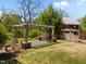 A backyard featuring a pergola, lush lawn, and the red building, perfect for relaxation and outdoor enjoyment at 109 N Hassel St, Hillsborough, NC 27278