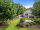 Picturesque backyard with lush lawn, garden beds, mature trees, and a charming pergola at 109 N Hassel St, Hillsborough, NC 27278