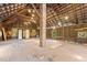 Rustic barn interior with wooden beams, exposed roof, brick chimney, weathered floor, and charming windows at 109 N Hassel St, Hillsborough, NC 27278