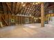 Spacious barn interior with exposed wooden beams, weathered floors, brick chimney, and vintage windows at 109 N Hassel St, Hillsborough, NC 27278