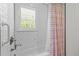 A relaxing bathroom with a white subway tile, window, and bathtub with a shower at 109 N Hassel St, Hillsborough, NC 27278