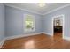 Empty bedroom featuring hardwood floors, a large window, and neutral paint, ready for personalization at 109 N Hassel St, Hillsborough, NC 27278