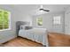 A serene bedroom featuring natural light, hardwood floors, and a ceiling fan at 109 N Hassel St, Hillsborough, NC 27278