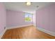 Bedroom featuring pink walls, hardwood floors, and a large window at 109 N Hassel St, Hillsborough, NC 27278