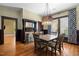 Charming dining room with a decorative chandelier, patterned curtains, and hardwood floors at 109 N Hassel St, Hillsborough, NC 27278
