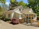 Charming white home featuring a decorative gate and mature trees in the front yard at 109 N Hassel St, Hillsborough, NC 27278