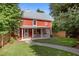 Charming red farmhouse-style home with a cozy front porch and a well-manicured lawn at 109 N Hassel St, Hillsborough, NC 27278