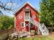 Unique red barn-style home featuring an elevated deck with outdoor seating and dual staircases at 109 N Hassel St, Hillsborough, NC 27278