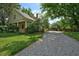 Charming two-story home features a welcoming front porch, gravel driveway, and mature trees at 109 N Hassel St, Hillsborough, NC 27278