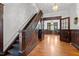Grand foyer with dark wood trim, staircase, and original doors at 109 N Hassel St, Hillsborough, NC 27278