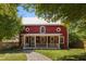 Quaint red home featuring a welcoming front porch and a stone walkway at 109 N Hassel St, Hillsborough, NC 27278