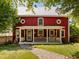 Charming two-story red house featuring a white porch with white columns and a stone walkway at 109 N Hassel St, Hillsborough, NC 27278