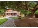 Charming red home with a welcoming front porch and beautifully landscaped yard under the shade of a mature tree at 109 N Hassel St, Hillsborough, NC 27278