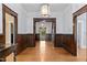 Open hallway featuring dark wood trim, white walls and hardwood floors, with multiple entryways at 109 N Hassel St, Hillsborough, NC 27278