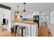 A charming kitchen featuring white cabinets, breakfast bar, wood countertops, and stainless appliances at 109 N Hassel St, Hillsborough, NC 27278