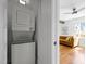 A laundry room with a white stacked washer and dryer, near the living room at 109 N Hassel St, Hillsborough, NC 27278