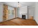 Bright living room with hardwood floors, fireplace, and large window with colorful, patterned curtains at 109 N Hassel St, Hillsborough, NC 27278