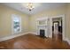 Bright living room with hardwood floors, a fireplace, and natural light streaming through the windows at 109 N Hassel St, Hillsborough, NC 27278