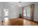 Inviting living room featuring hardwood floors and large windows adorned with colorful curtains at 109 N Hassel St, Hillsborough, NC 27278