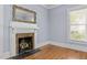 Close up on a fireplace and gold mirror in a living room with hardwood floors at 109 N Hassel St, Hillsborough, NC 27278