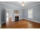 Living room showcasing a fireplace, two windows providing natural light, and hardwood flooring at 109 N Hassel St, Hillsborough, NC 27278