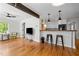 Open-concept living area with hardwood floors, a breakfast bar, and modern lighting fixtures at 109 N Hassel St, Hillsborough, NC 27278