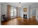 Bright living room with hardwood floors, a fireplace, and large windows with decorative curtains at 109 N Hassel St, Hillsborough, NC 27278