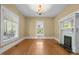 Inviting living room featuring hardwood floors, a fireplace, and bright windows at 109 N Hassel St, Hillsborough, NC 27278