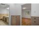 Hallway view of bathroom, cabinet, and bedroom with hardwood floors and window at 110 Omega Rd, Henderson, NC 27536