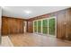 Living room with wood paneling, new floors, and sliding glass doors that let in natural light at 110 Omega Rd, Henderson, NC 27536