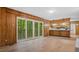 Bright living room featuring wood paneling, new floors, and sliding glass doors at 110 Omega Rd, Henderson, NC 27536