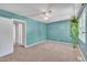 Bright bedroom boasts teal walls, neutral carpet, ceiling fan, and a hallway view at 121 Drumbuie Pl, Garner, NC 27529