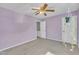 An inviting bedroom features soft purple walls, neutral carpet, ceiling fan, and a view to the hallway at 121 Drumbuie Pl, Garner, NC 27529