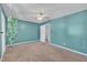 Well-lit bedroom features teal walls, neutral carpet, ceiling fan, and ample natural light at 121 Drumbuie Pl, Garner, NC 27529